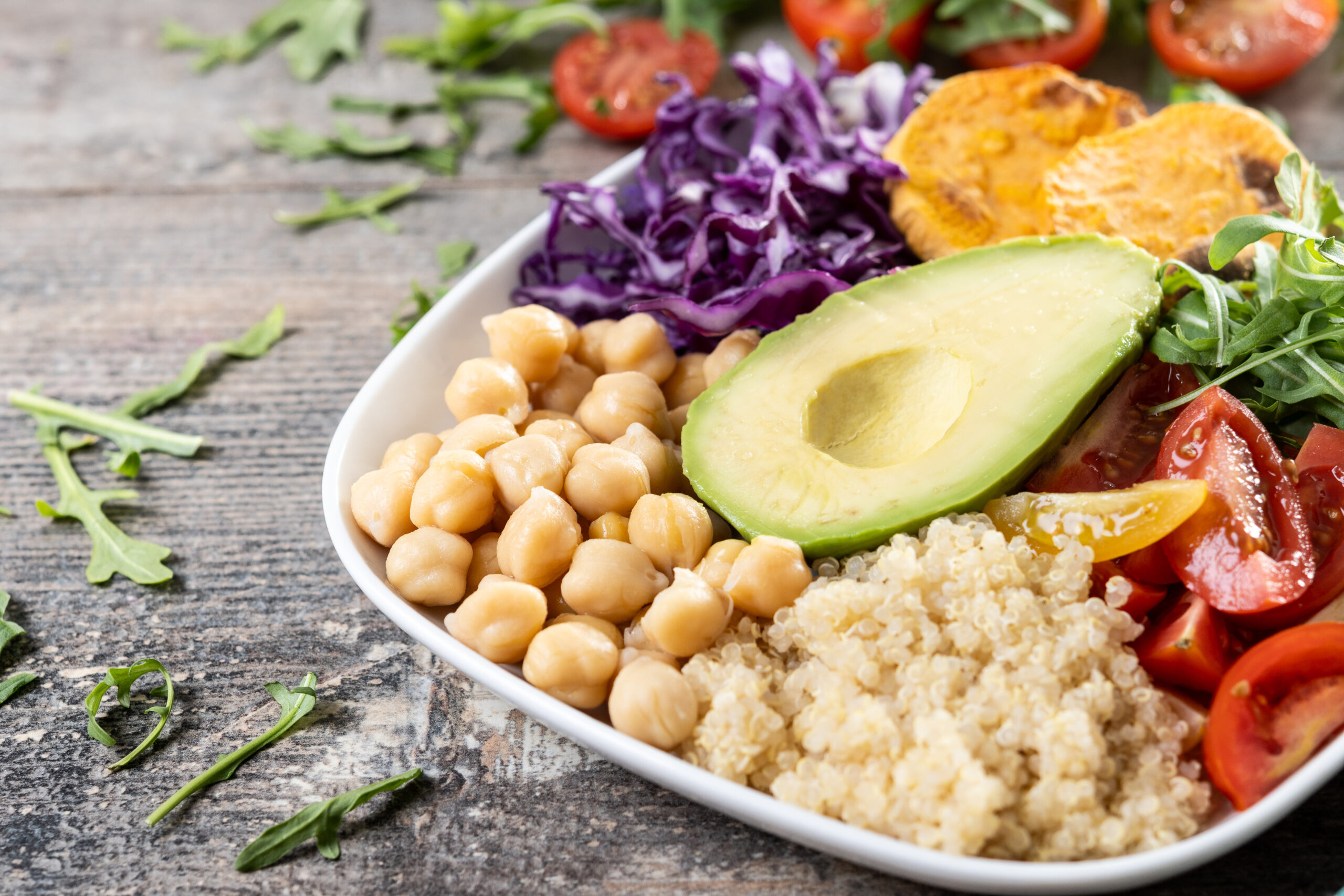 Healthy salad with avocado,lettuce,tomato and chickpeas on wooden table